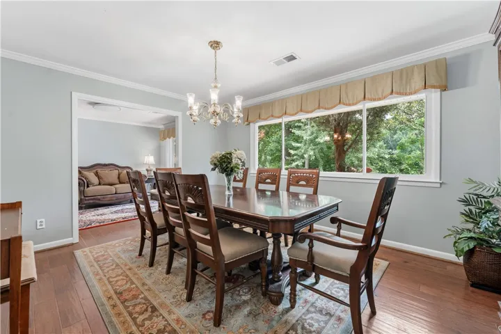 Hardwood floors and a grand chandelier elevate this spacious dining room.