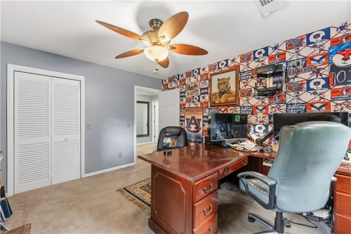 Functional home office or study with comfortable carpet and overhead illumination.