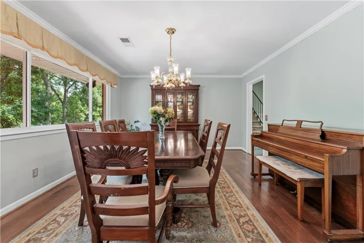A refined dining space features crown molding, wood flooring, and a chandelier, perfect for memorable gatherings.