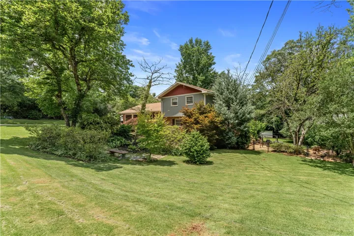 A verdant yard envelops this charming residence, offering ample outdoor living space.