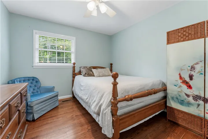 A comforting bedroom with hardwood floors offers a tranquil retreat.
