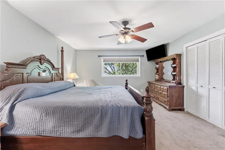 A spacious primary bedroom featuring comfortable carpet flooring and ample closet space.
