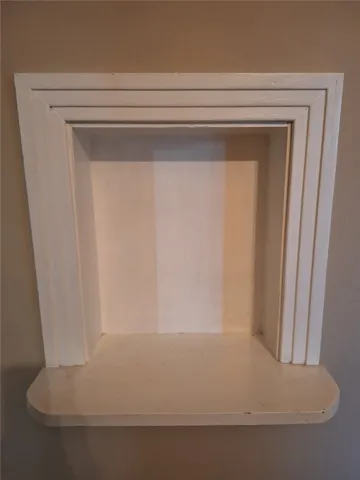 A decorative mantelpiece provides a charming focal point, awaiting personalized touches.