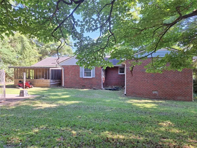 A classic brick exterior offers enduring appeal with a covered side patio, perfect for outdoor relaxation.