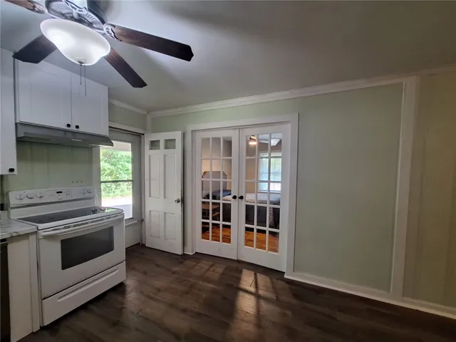A well-lit kitchen featuring rich wood flooring and practical overhead storage.