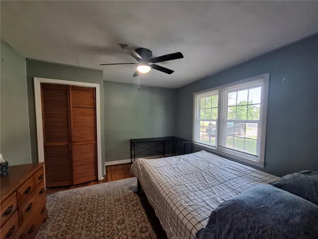 Well-lit sleeping quarters with a ceiling fan, wood flooring, and ample natural light.