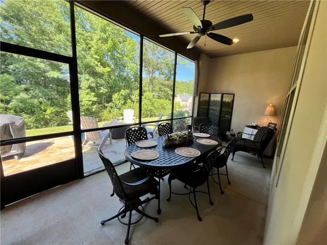 An inviting screened porch provides a serene outdoor living space, perfect for dining and relaxation.