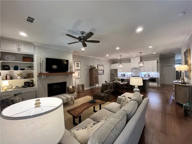 An inviting open-concept living space features warm hardwood floors and a modern fireplace.