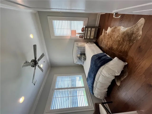 Hardwood floors and bright windows define this comfortable bedroom space.