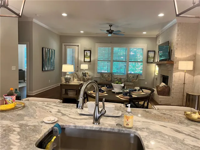 Well-lit living space with a fireplace and large windows provides an inviting atmosphere for daily living and entertaining.