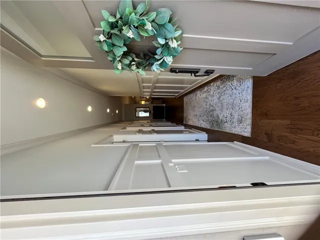A well-lit corridor welcomes you home with warm recessed lighting and rich hardwood flooring.