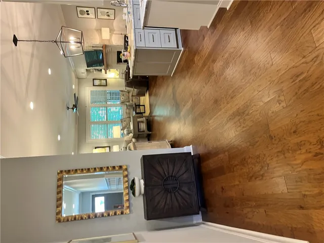 Natural wood flooring extends throughout this inviting, open-concept living and kitchen area.
