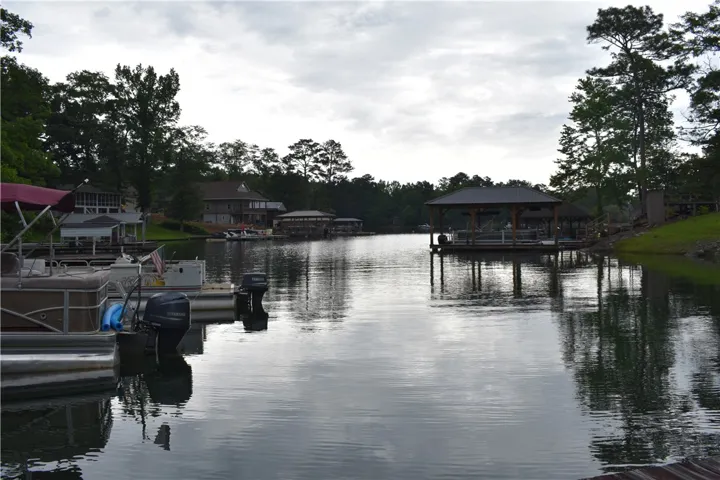 Boats dock by a charming boathouse with serene waterfront views.