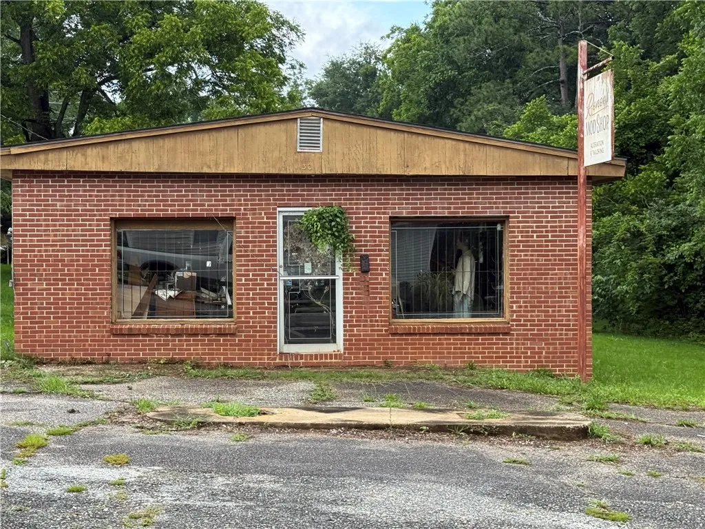 A brick building with prominent storefront windows awaits its next chapter, offering a flexible space for diverse ventures.