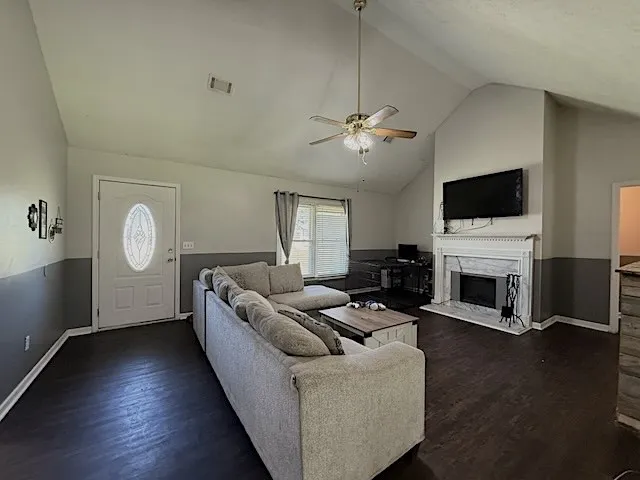 A welcoming living area boasts high vaulted ceilings and a classic fireplace.