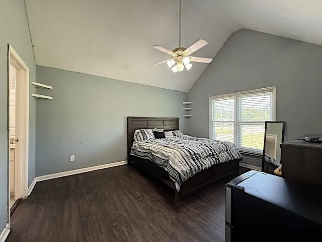 Relax in this tranquil bedroom, featuring a soaring vaulted ceiling and a cooling overhead fan.
