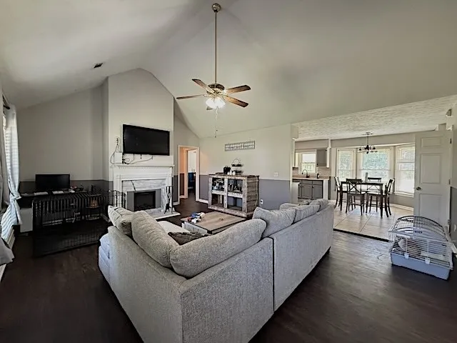 A spacious living area with vaulted ceilings transitions seamlessly into a dining nook and kitchen.