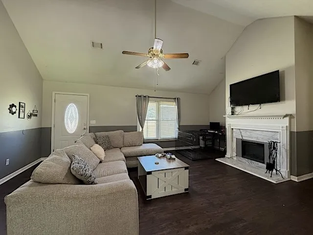 A welcoming living room features a fireplace and rich dark hardwood flooring.