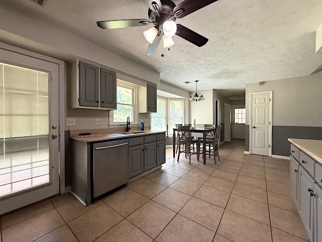 A well-lit kitchen with sleek appliances and abundant space for dining.