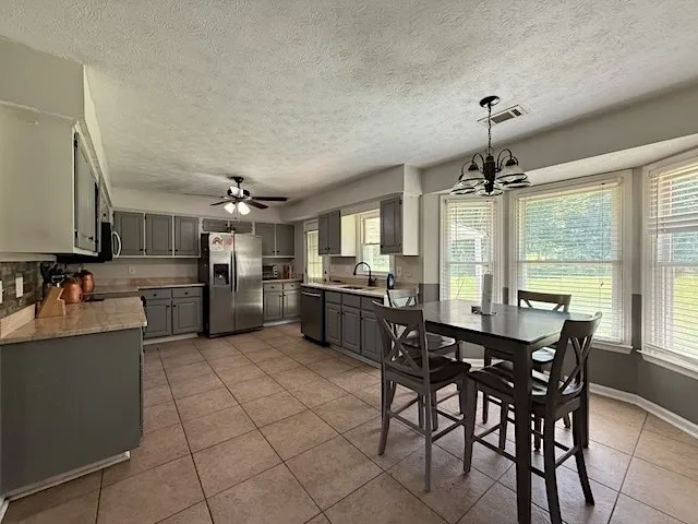 A well-appointed kitchen offers ample cabinetry, modern appliances, and a casual dining space with bright bay windows.