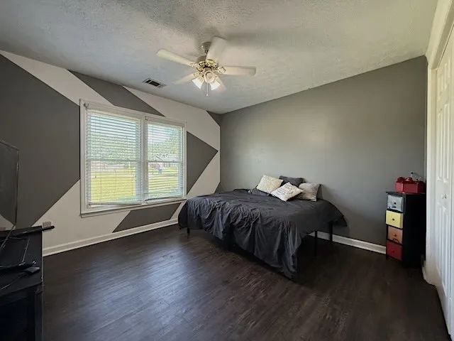 Well-lit sleeping quarters with a decorative accent wall and durable flooring for effortless upkeep.