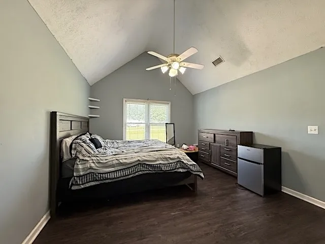 A peaceful sleeping space features vaulted ceilings and rich wood flooring.