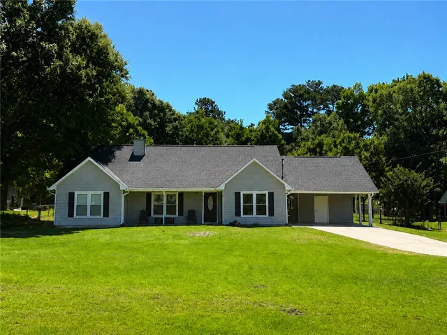 A classic ranch home nestled among abundant greenery with a welcoming front yard.