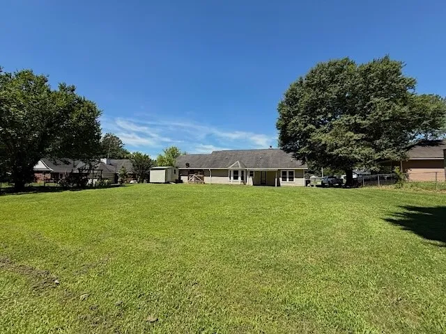 A spacious backyard with mature trees offers ample room for outdoor activities.