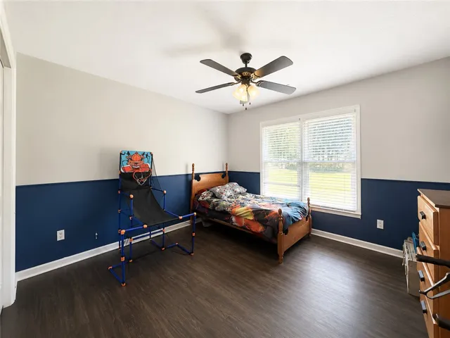 Well-lit sleeping quarters with rich wood flooring and a refreshing window view.