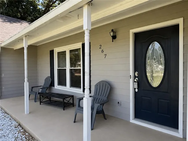 A welcoming covered front porch with classic white columns sets a charming first impression.