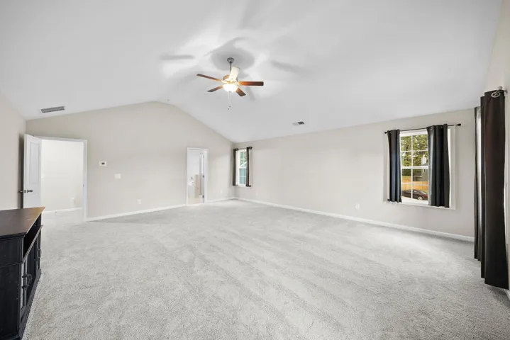 Vast carpeted area with vaulted ceilings offers versatile living possibilities.