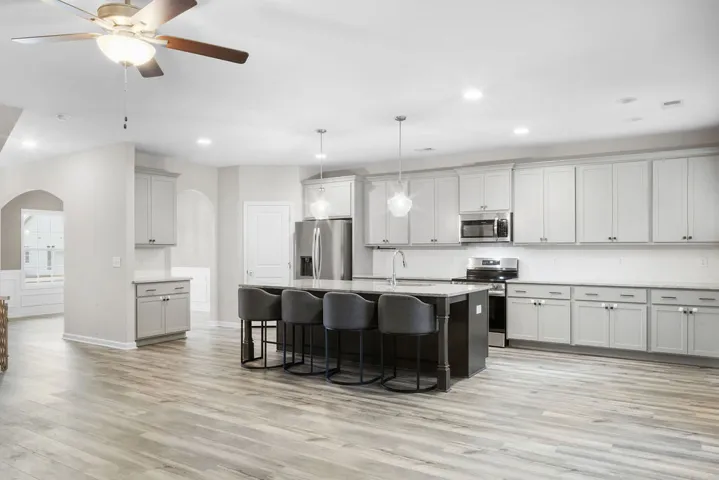 Modern cabinetry and lustrous countertops define this inviting, open-concept culinary space.