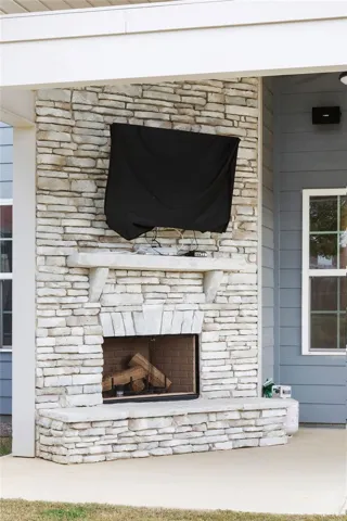 An inviting stone-clad fireplace creates a focal point for outdoor gatherings.