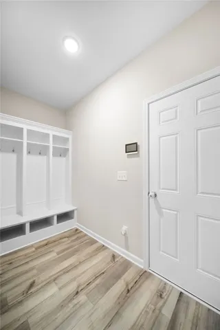 A well-lit mudroom features built-in storage cubbies and a durable wood floor.