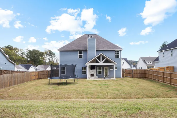 A spacious backyard with a private fence, featuring a covered patio for outdoor enjoyment.