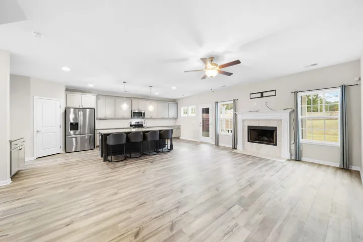 An open-concept living area features a contemporary kitchen island and a cozy fireplace, creating an inviting atmosphere.