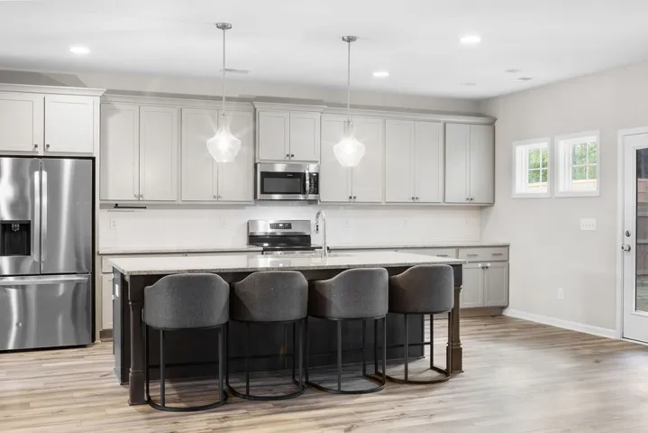 Culinary creations come to life in this kitchen, featuring an eat-in island and stainless appliances.