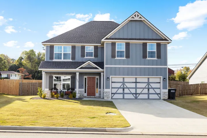 A classic two-story residence with a welcoming front porch and a well-kept lawn awaits.