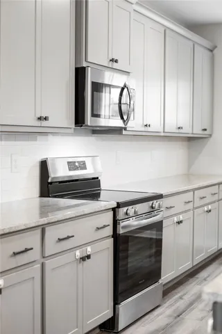 Culinary adventures await in this kitchen featuring abundant cabinetry and sleek, modern appliances.