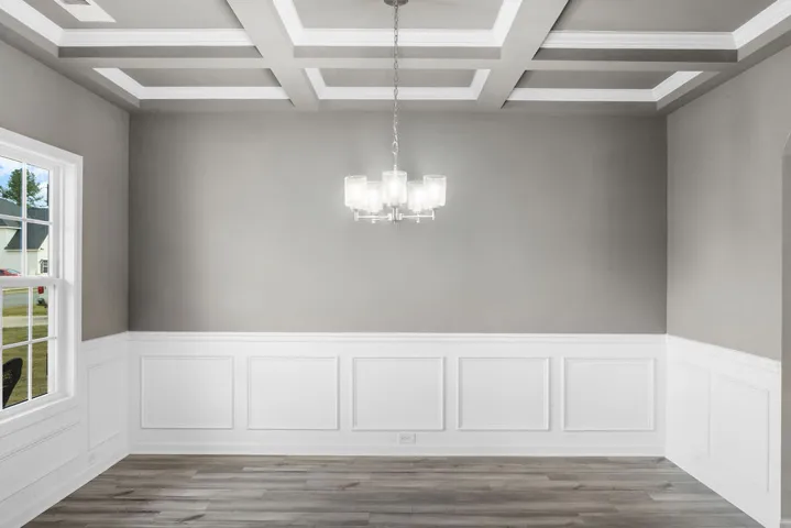 Elegant coffered ceilings and wainscoting adorn this versatile dining area, ready for personalization.