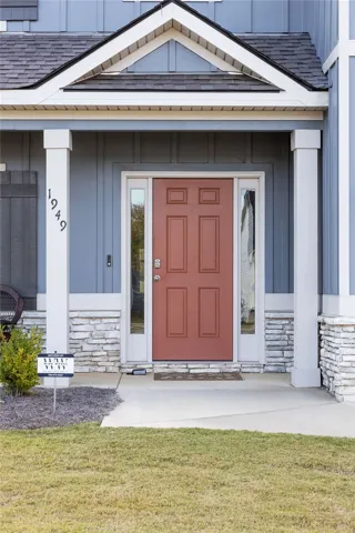 A welcoming front entry with a vibrant door, framed by stacked stone accents and classic white columns.