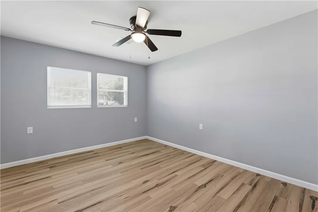 A quiet retreat featuring durable wood flooring and an overhead ceiling fan for optimal comfort.