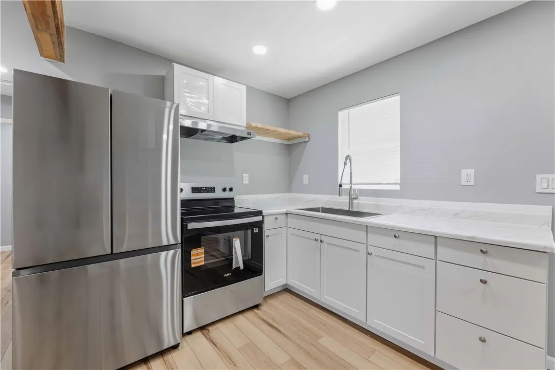 Modern kitchen with sleek stainless-steel appliances and light wood flooring.