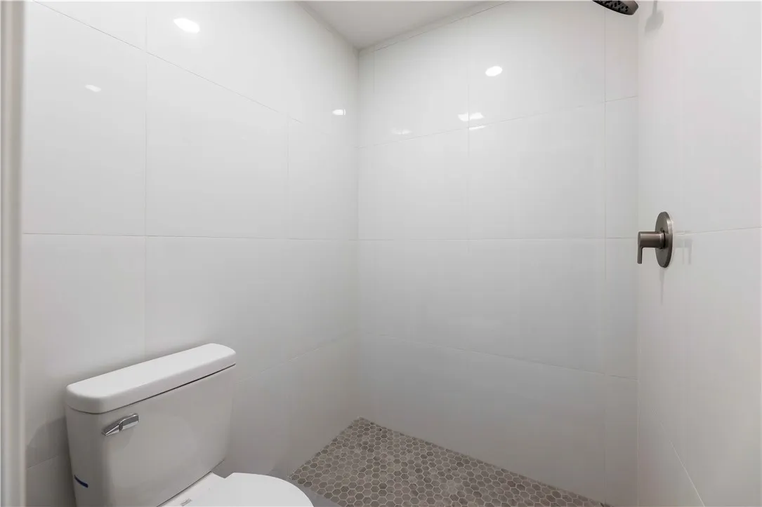 A well-appointed, compact bath featuring a walk-in shower and clean, tiled surfaces.
