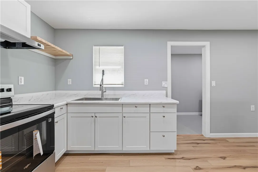 A well-equipped kitchen showcasing elegant countertops and natural wood flooring.