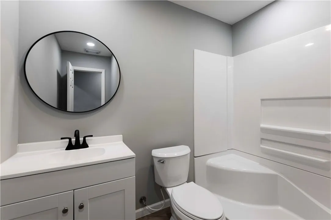 A well-appointed bath features a sleek vanity, modern mirror, and a convenient shower-tub combination.