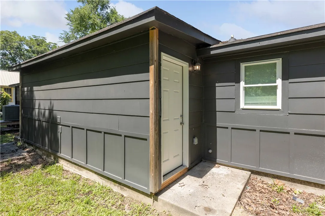 A side entrance offers practical access to this structure, featuring durable siding and a clean aesthetic.