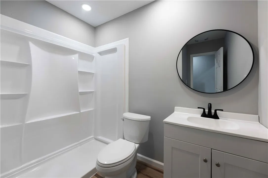 Functional full bathroom featuring a white shower and modern vanity.