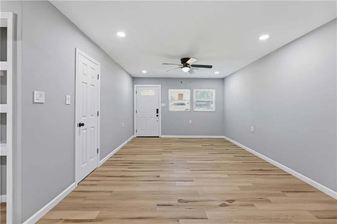 A naturally illuminated living area featuring gleaming hardwood floors and ample lighting.