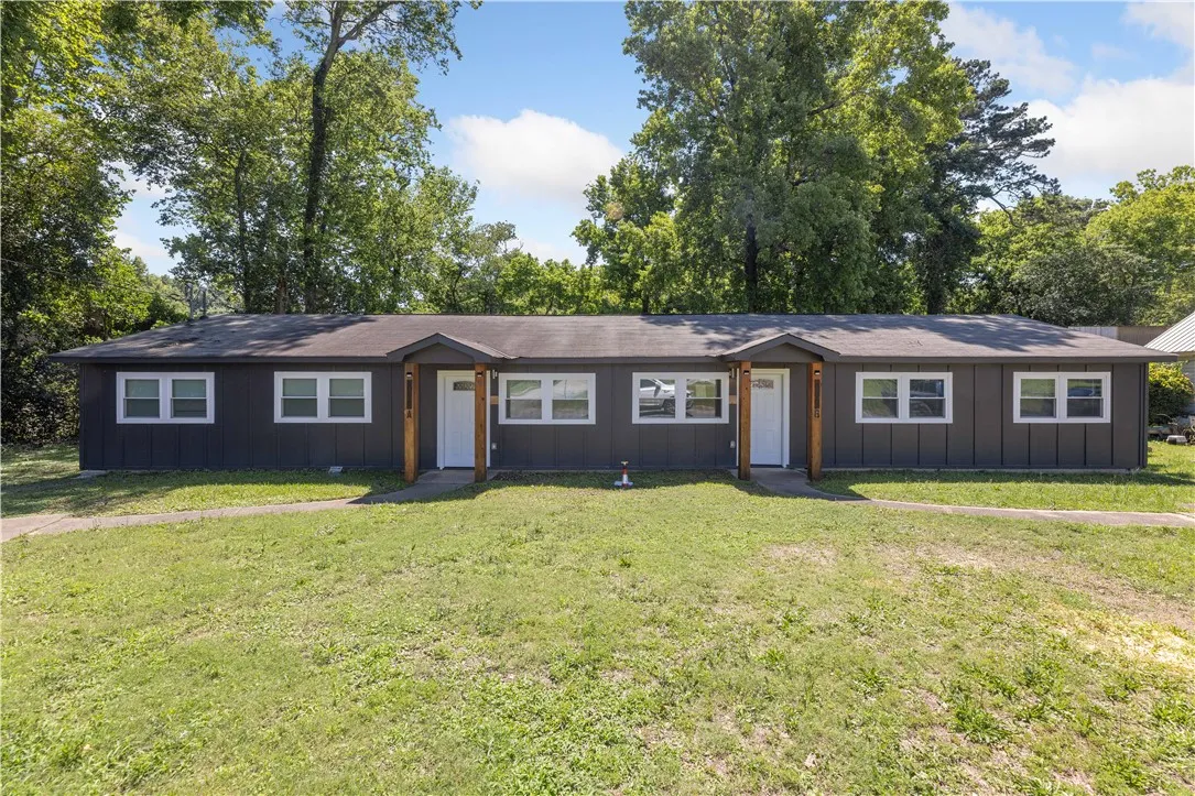 Two identical residential units share a continuous front yard and covered entries.